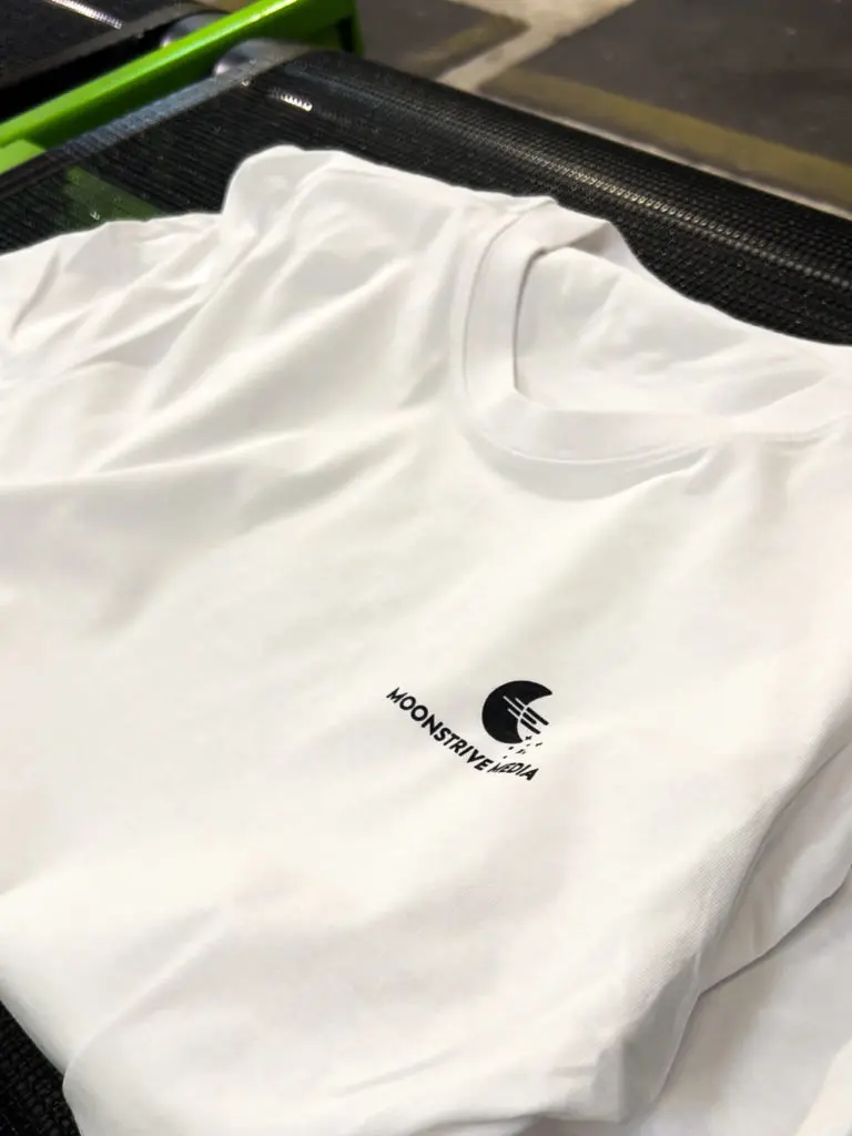 Fertig bedrucktes Build Your Brand Round Neck T-Shirt für Moonstrive Media