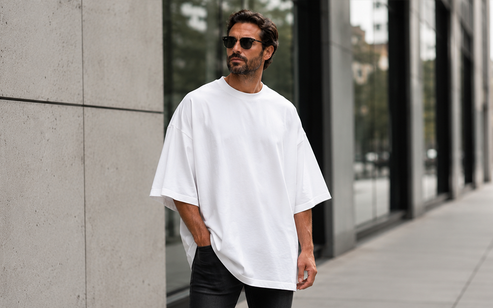 Mann trägt Build Your Brand Huge Tee BY193 in Weiß – Extra Oversized Fit